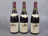 three bottles of wine are lined up on a gray surface
