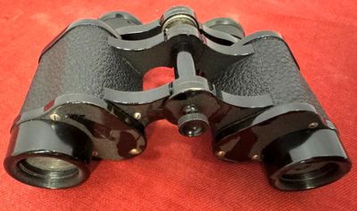 a pair of binoculars that are on a red surface