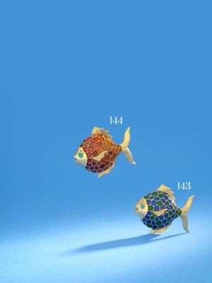 Deux broches colorées en forme de poisson sont représentées sur un fond bleu
