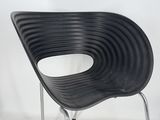 a black chair that is sitting on a metal stand