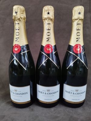 trois bouteilles de champagne posées les unes à côté des autres sur une table