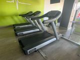 Plusieurs steppers sont alignés les uns à côté des autres dans une salle de sport