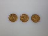 three gold coins, one of which is a sovereign and one of which is a sovereign