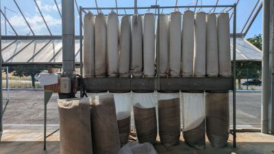 de nombreux rouleaux de tissu posés sur un support devant un bâtiment