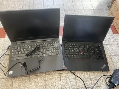 two open laptop computers sitting on a tiled floor next to each other