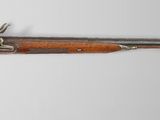 an old rifle with a wooden barrel and a metal handle