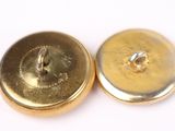 a close up of a pair of gold buttons on a white surface