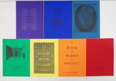 several books are lined up in a row on a white surface