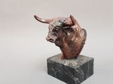 sculpture représentant une tête de taureau posée sur un socle en marbre, sur fond blanc