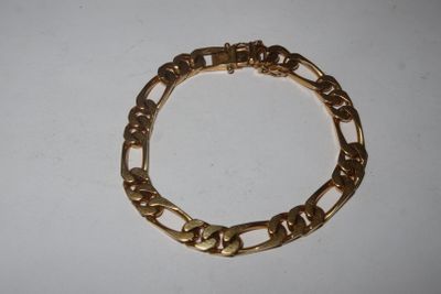a close up of a gold bracelet on a white surface