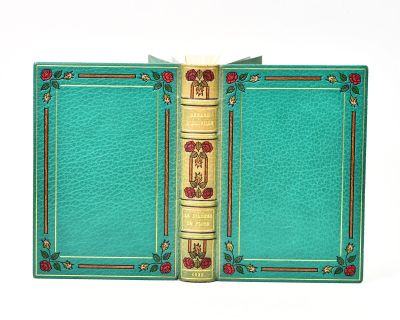 a green book with gold trim and a red rose on the cover