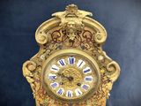 a gold clock with blue and white roman numerals on it