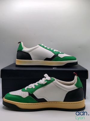 a pair of green and white sneakers sitting on top of a box