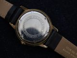 a close up of a watch on a black surface