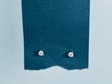 un gros plan sur une paire de boucles d'oreilles posées sur un morceau de tissu bleu