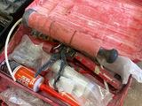 une caisse à outils rouge avec des outils sur le sol