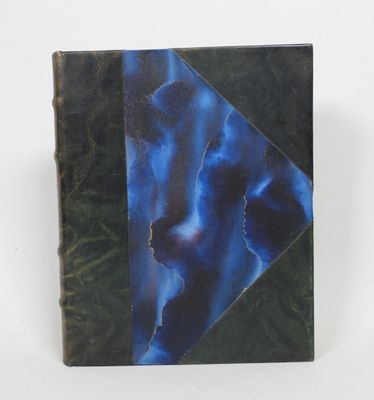 un vieux livre à la couverture bleue posé sur une table blanche