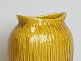 a yellow vase that is sitting on a table