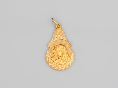 un pendentif en or sur lequel est représentée une femme