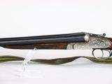 a close up of a rifle on a white background with a green ribbon