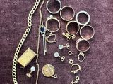 a bunch of jewelry that is laying out on a purple cloth