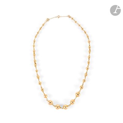 a gold beaded necklace on a white background