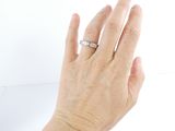 a woman ' s hand with a diamond ring on it