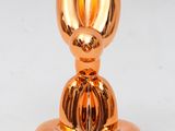 an image of a gold colored candle holder with a rabbit head on top of it