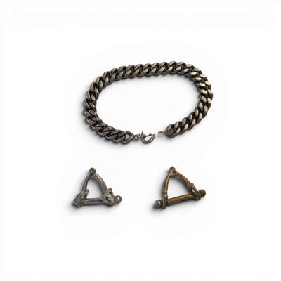 a close up of a metal bracelet with a triangle and two other items