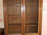 un meuble en bois avec des portes en verre dans le coin d'une pièce