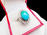 an image of a ring in a red box with a turquoise stone in it