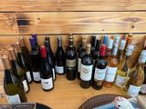 plusieurs bouteilles de vin posées sur une table, à côté d'une assiette de nourriture