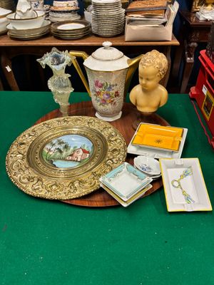 une table verte sur laquelle se trouvent une assiette dorée et d'autres objets