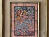 framed painting of a woman riding an elephant with a man on it