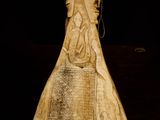 a carved vase sitting on a table with a black background