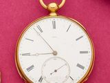 une montre de poche en or avec des chiffres romains sur un cadran rose