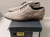 quelqu'un porte une paire de chaussures posées sur une boîte