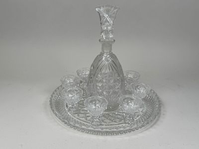 a glass bottle on a tray on a white surface