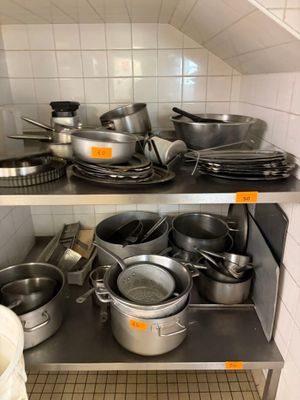 de nombreuses casseroles et poêles sur les étagères de la cuisine