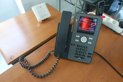 un téléphone posé sur un bureau à côté d'un autre téléphone
