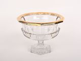 un bol en verre transparent bordé d'or, posé sur un fond blanc