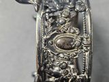 a close up of a silver bracelet with a design on it