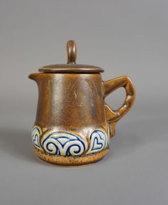 théière en céramique marron et bleue avec un couvercle