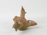 a small clay bird that is sitting on the ground