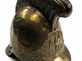a bronze helmet on a stand on a white surface