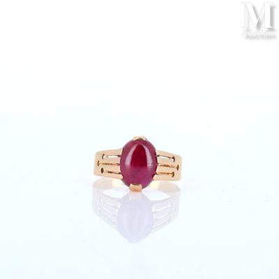 an image of a ring with a red stone on a white surface