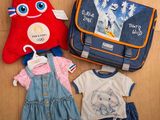 une valise, un sac et quelques vêtements étalés par terre