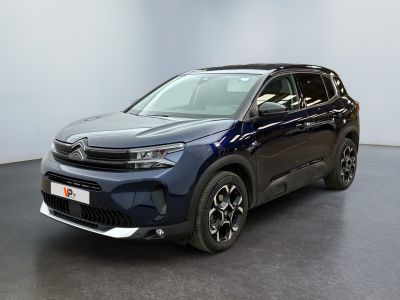 un SUV bleu garé dans une pièce au sol noir