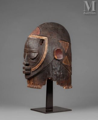 a wooden mask on a stand on a gray background