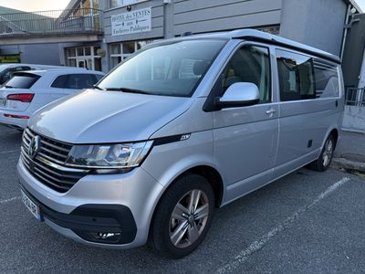 La camionnette argentée est garée sur un parking, à côté d'autres voitures.